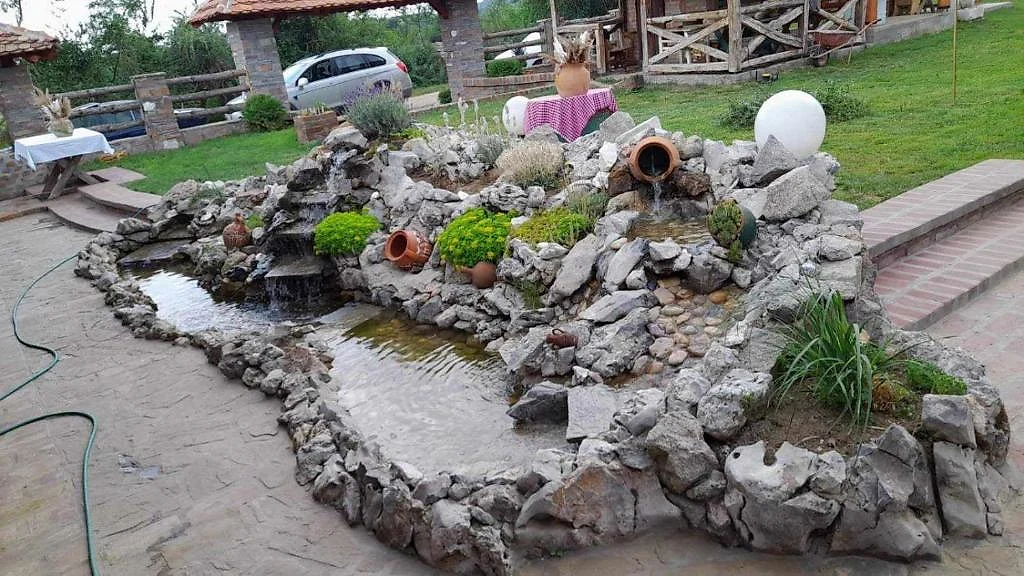 Kameni vrt sa jezercem i brvnarama u pozadini