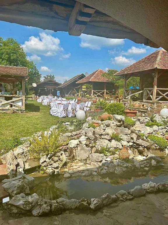 Pogled na Etno selo Pepe sa brvnarama, baštom i jezercem