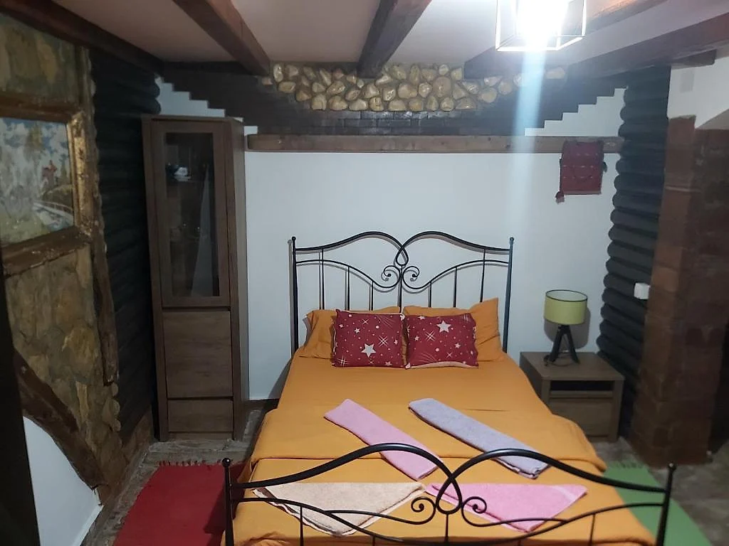 Etno soba sa kovanim krevetom i žutom posteljinom