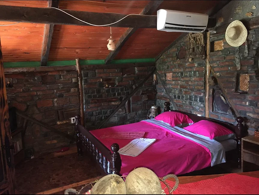 Potkrovni apartman sa drvenim krevetom i etno detaljima